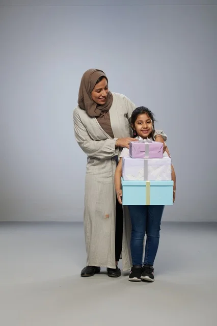 أم وطفلة عربية مع صناديق هدايا في الاستوديو