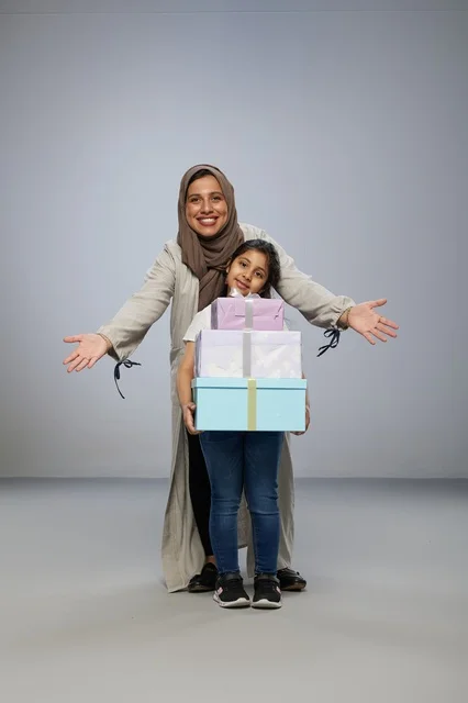 Saudi Mother and Daughter with Stack of Gift Boxes