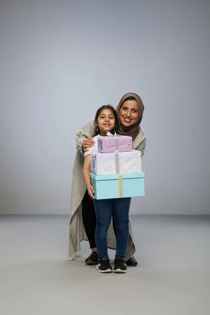 Arab Mother and Daughter Holding Gift Boxes in Studio