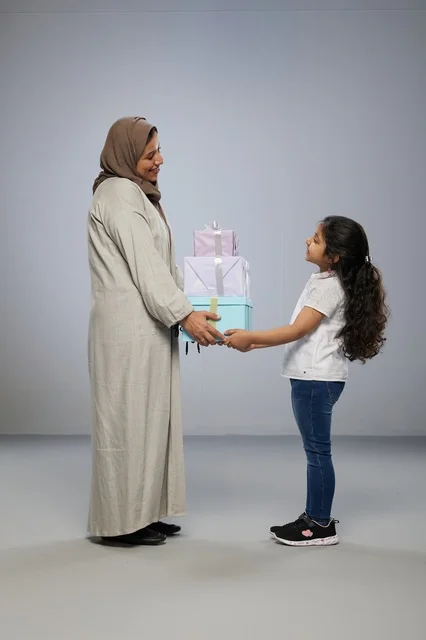 أم وابنتها مع صناديق هدايا في استوديو