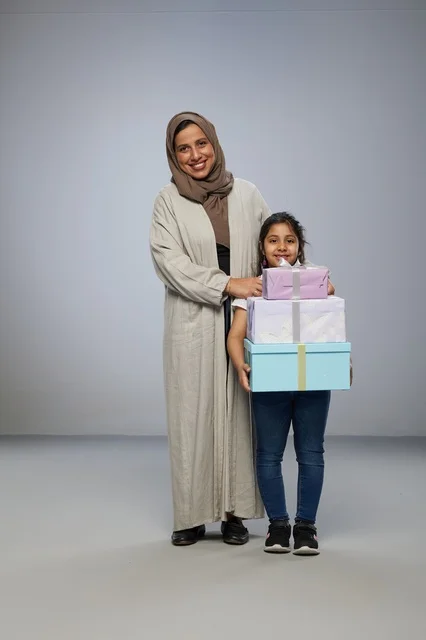 أم سعودية وابنتها مع صناديق هدايا في الاستوديو