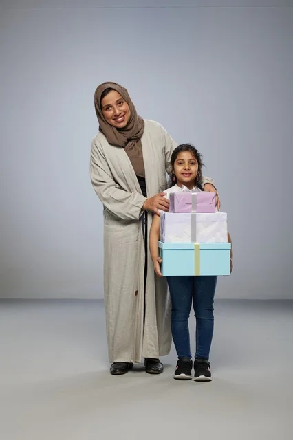 أم وطفلتها مع صناديق هدايا في استوديو