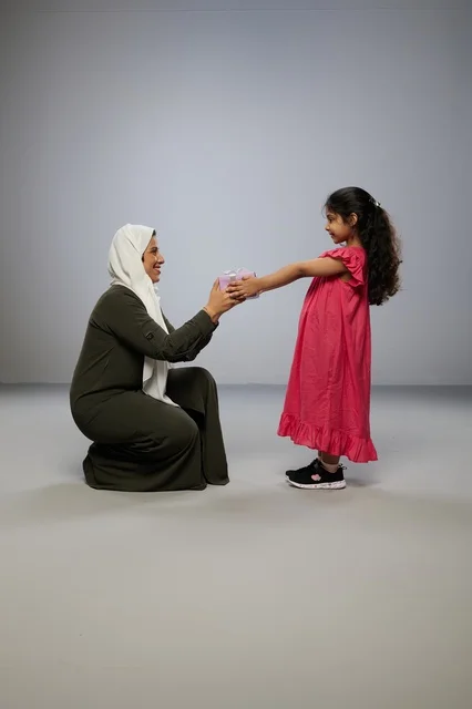 Arab Girl Giving Gift Box to Mother in Studio