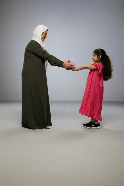 Arab Girl Giving Pink Gift Box to Mother in Studio