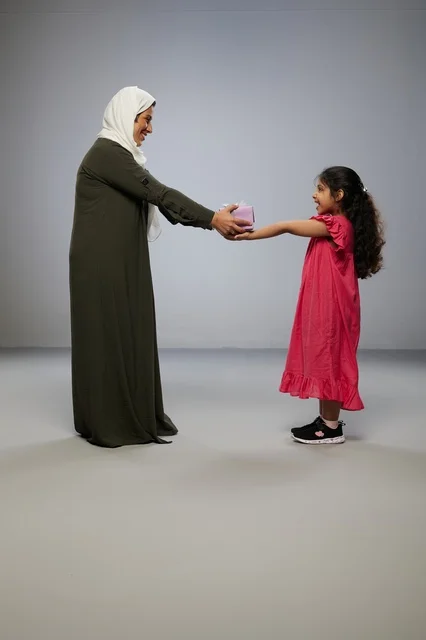 طفلة تقدم هدية لوالدتها في استوديو تصوير