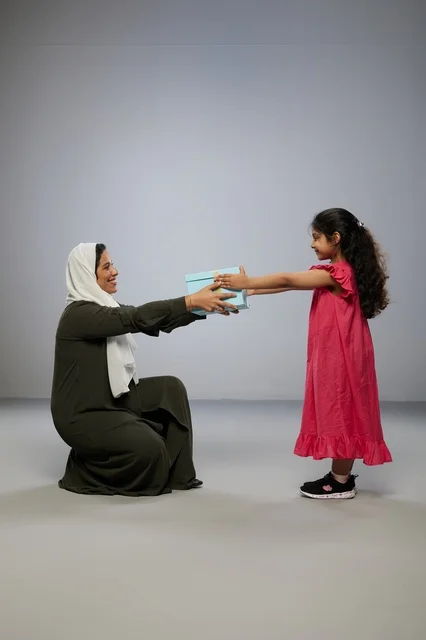 طفلة تقدم صندوق هدية لوالدتها بالعباية