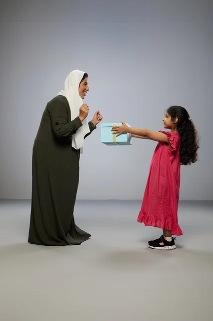 أم وطفلة عربية مع صندوق هدايا في الاستوديو