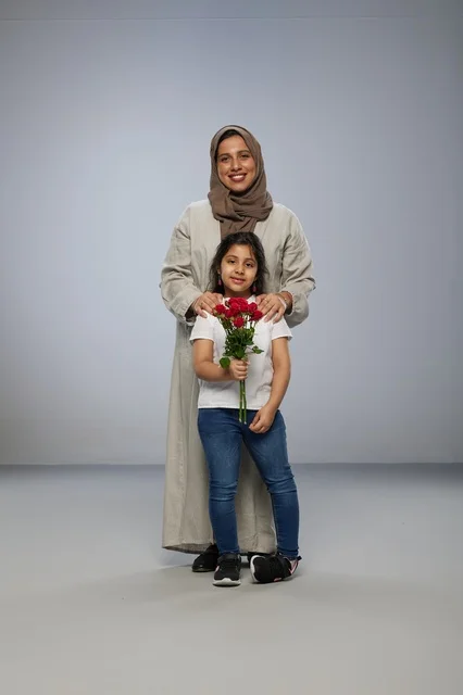 أم وابنة عربية مع باقة ورد حمراء في استوديو أم وابنة عربية مع باقة ورد حمراء في استوديو
