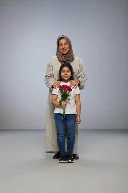 أم وطفلة عربية مع ورود حمراء في الاستوديو