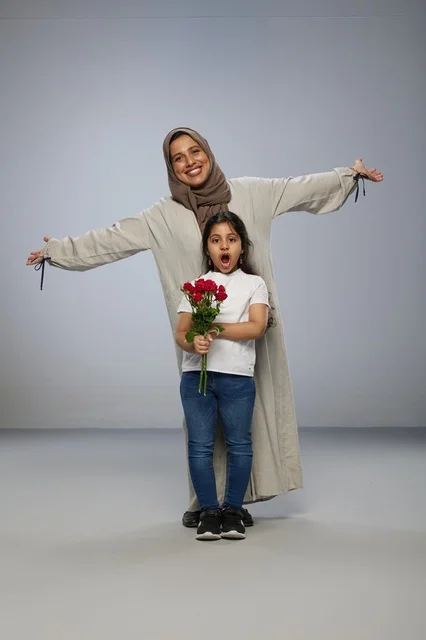 أم وطفلة عربية مع ورود حمراء في استوديو