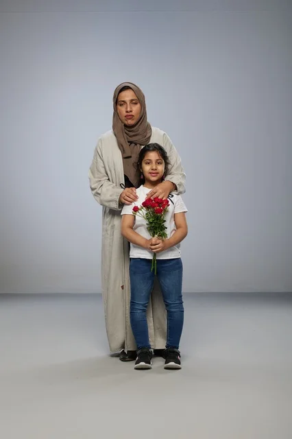 أم وطفلة عربية مع ورود حمراء في الاستوديو