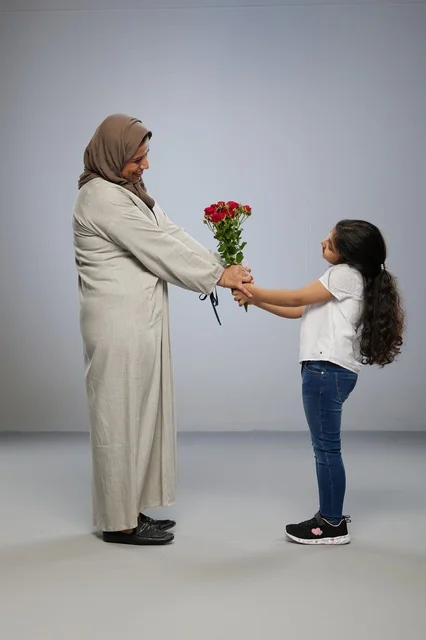 Daughter Giving Red Roses to Mother in Traditional Abaya