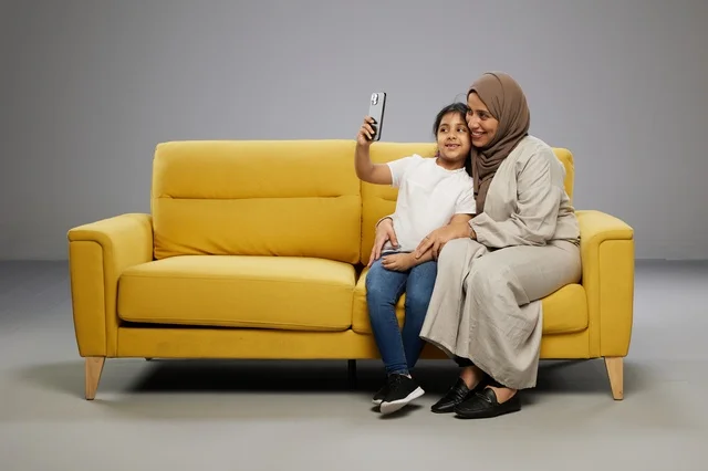 Arab Mother and Daughter Selfie on Yellow Sofa
