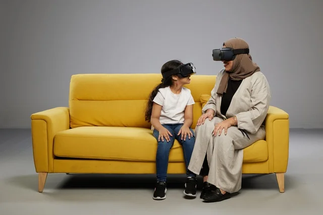 Arab Mother and Daughter using VR Headset on Yellow Sofa