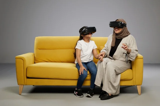 Arab Mother and Daughter with VR Headsets on Yellow Sofa