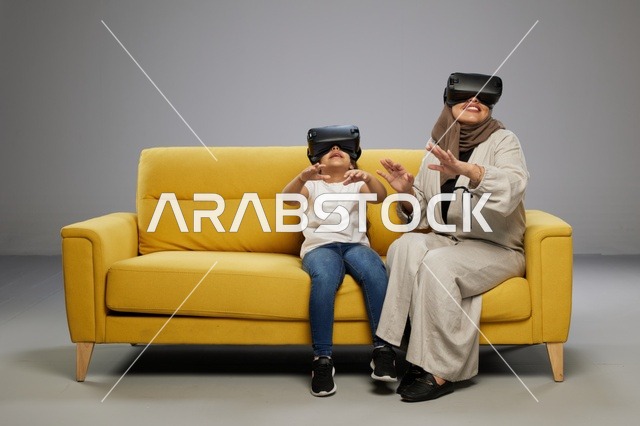 أم وابنتها تستخدمان نظارات الواقع الافتراضي على الأريكة