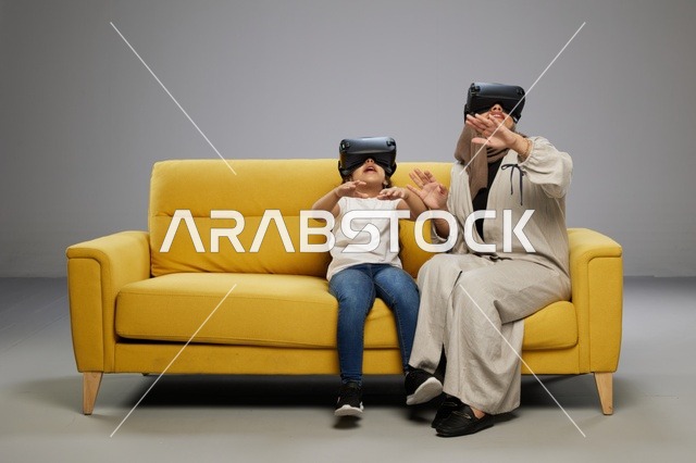 أم وابنتها تستخدمان نظارات الواقع الافتراضي على الأريكة