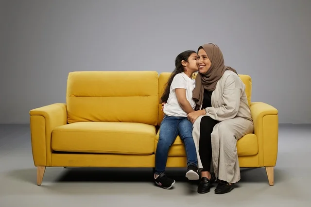 Arab Mother and Daughter Sitting on Yellow Sofa Studio