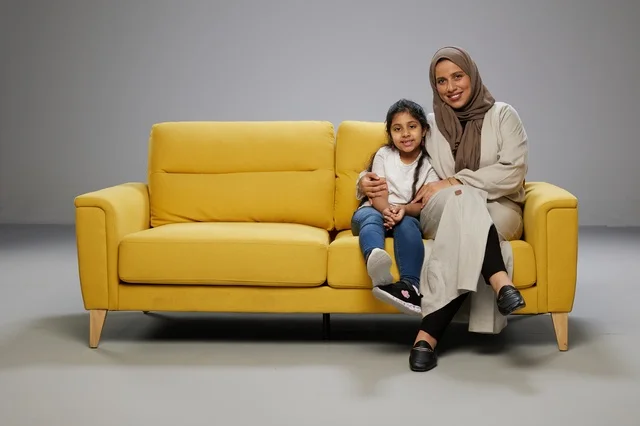 Arab Mother and Daughter on Yellow Sofa Studio Portrait