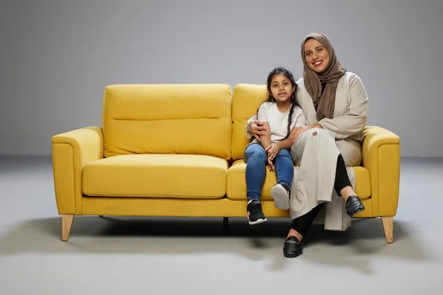 Arab Mother and Daughter on Yellow Sofa Studio Shot