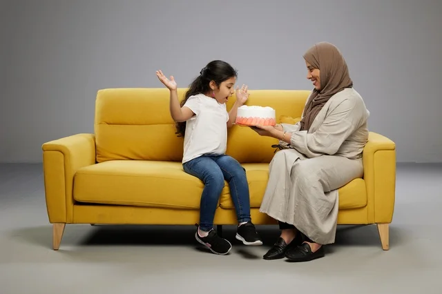 أم عربية تفاجئ ابنتها بكعكة على أريكة صفراء