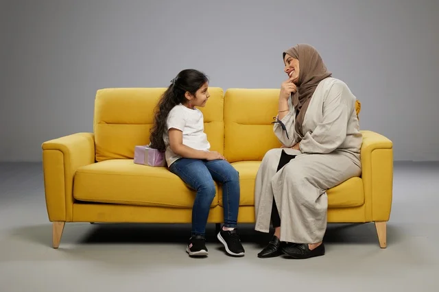 Arab Girl Hiding Gift for Mother on Yellow Sofa
