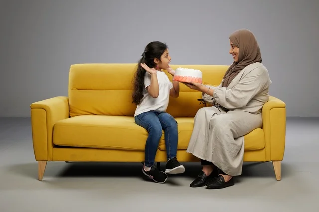 أم عربية تفاجئ ابنتها بكعكة على أريكة صفراء
