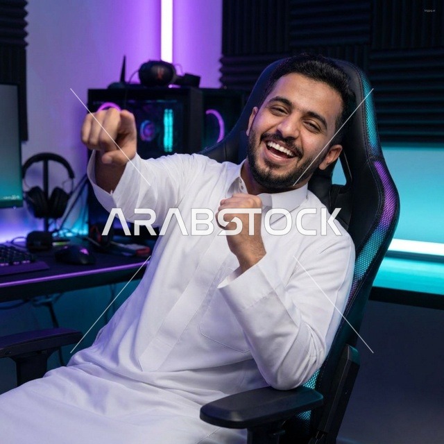 شاب سعودي بالثوب يحتفل بالفوز داخل غرفة الألعاب الإلكترونية