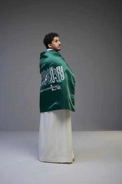 Saudi Man Wrapped in National Flag wearing Thobe