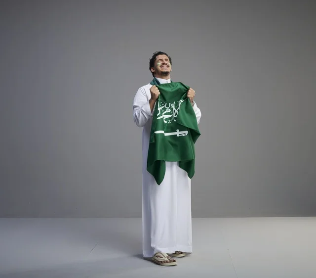 Smiling Saudi Man Holding Saudi Arabia National Flag