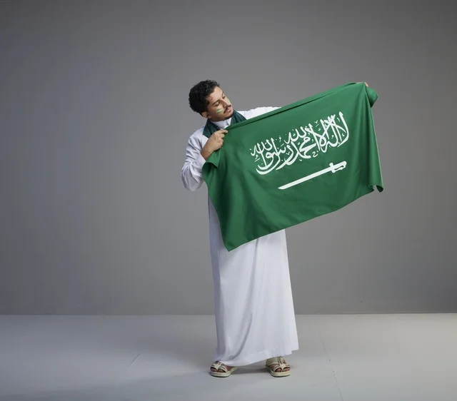 Saudi Man Holding National Flag in Studio