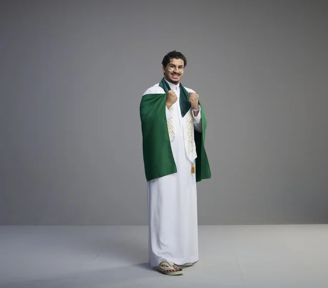 شاب سعودي يحمل العلم الوطني في الاستوديو