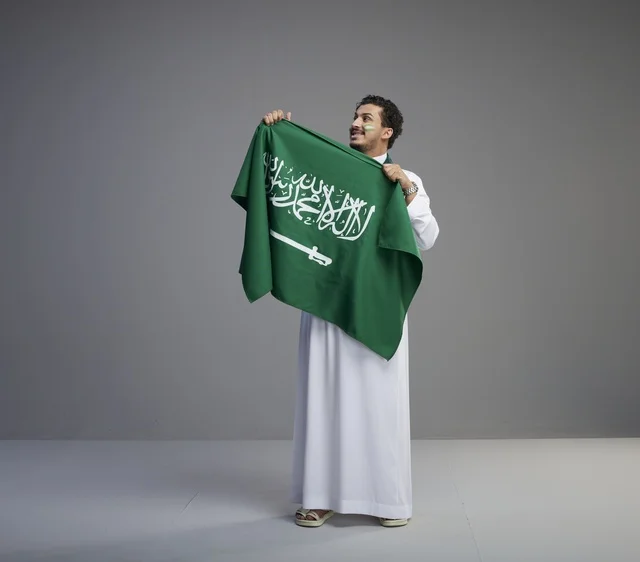Saudi Man Holding National Flag Studio Portrait