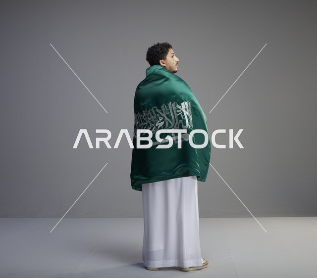 شاب سعودي يرتدي علم المملكة في الاستوديو
