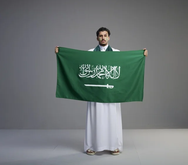 Saudi Man Holding National Flag on Gray Background