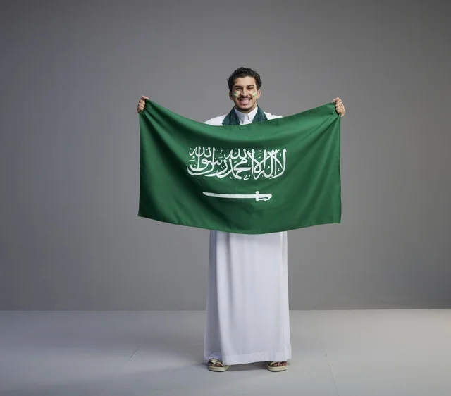 شاب سعودي يحمل العلم الوطني في الاستوديو