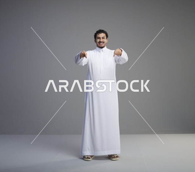 شاب سعودي بالثوب التقليدي يحتفل باليوم الوطني