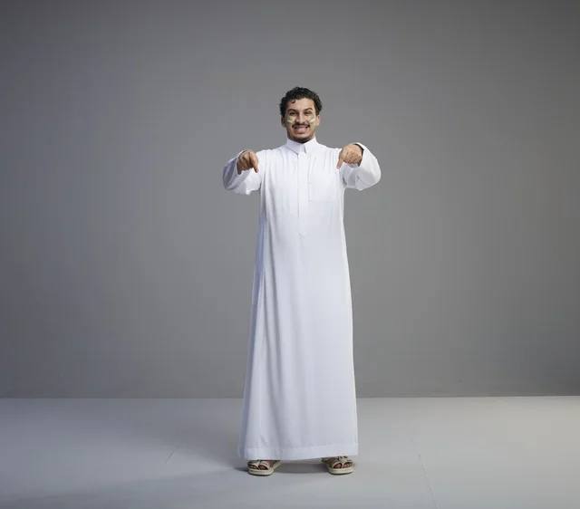 شاب سعودي بالثوب التقليدي يحتفل باليوم الوطني