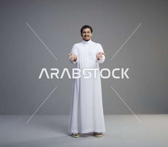 شاب سعودي بالثوب التقليدي يحتفل باليوم الوطني