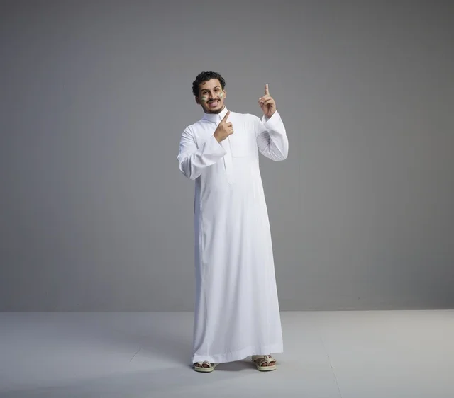 شاب سعودي بالثوب التقليدي يحتفل باليوم الوطني في استوديو