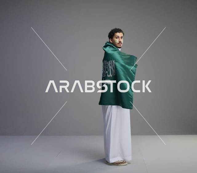 شاب سعودي يلتف بعلم المملكة العربية السعودية