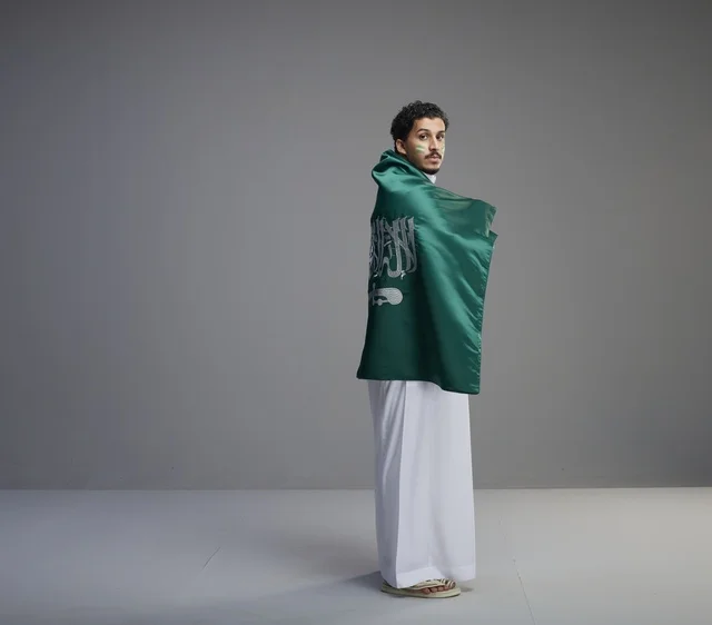 شاب سعودي يلتف بعلم المملكة العربية السعودية