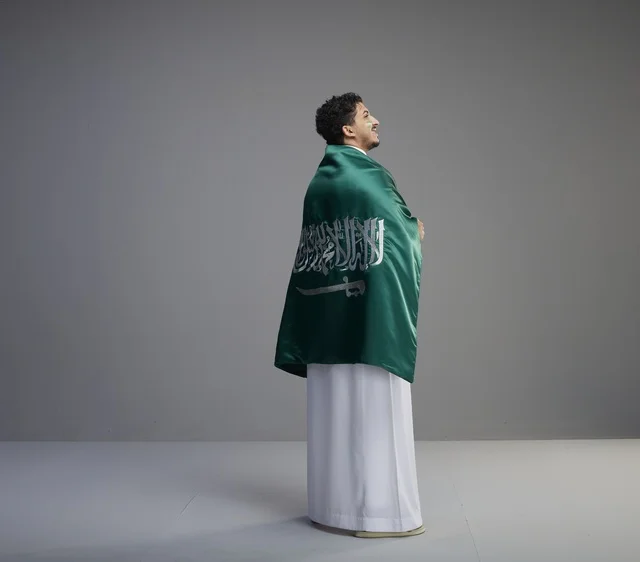شاب سعودي يلتف بالعلم في اليوم الوطني السعودي