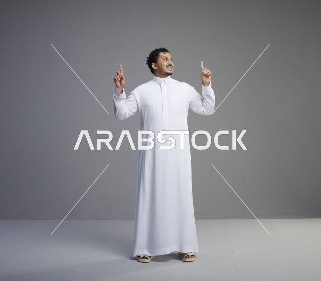 شاب سعودي برسمة وجه وطنية يشير للأعلى