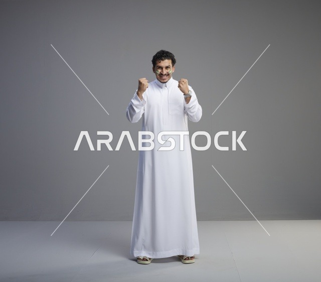 شاب سعودي بالثوب الأبيض يحتفل باليوم الوطني السعودي