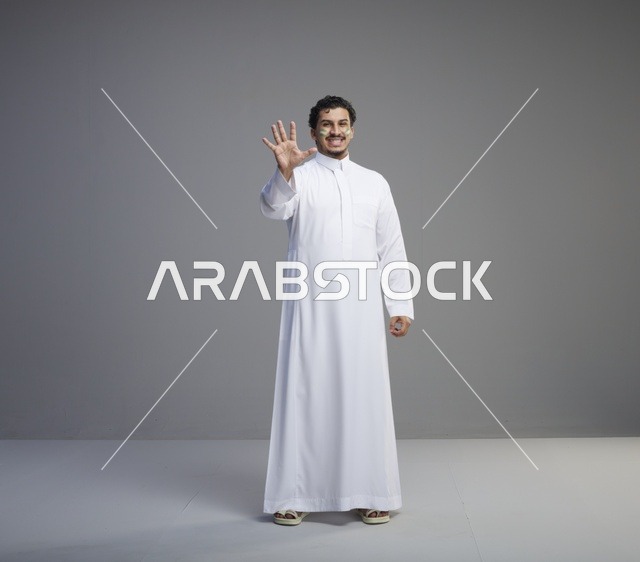 شاب سعودي بالثوب التقليدي يحتفل برسم على الوجه في استوديو