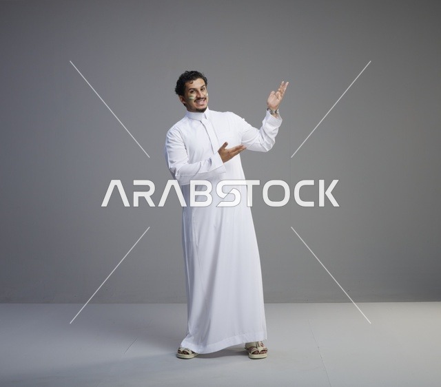 شاب سعودي بطلاء وجه يشير للاحتفال باليوم الوطني