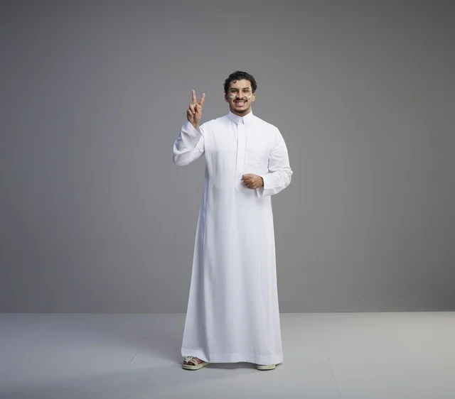 Saudi Man in White Thobe Celebrating with Victory Sign Saudi Man in White Thobe Celebrating with Victory Sign