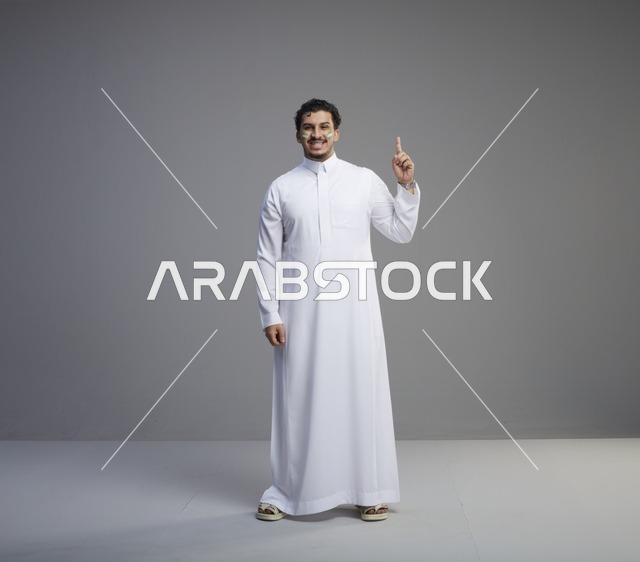 شاب سعودي بالثوب يحتفل باليوم الوطني في استوديو