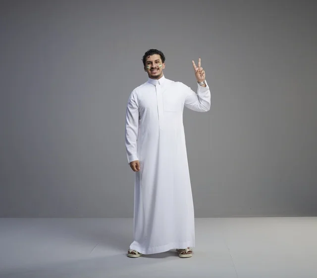 شاب سعودي بالثوب الأبيض يرفع علامة النصر